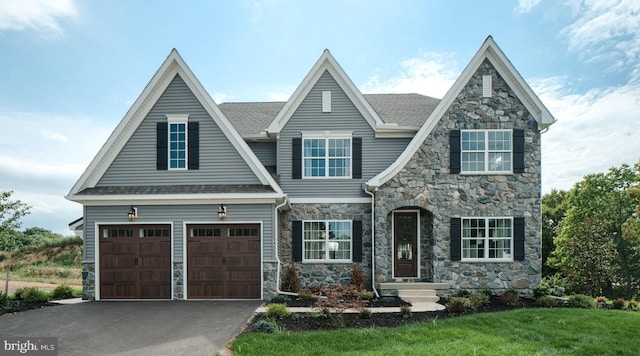 view of front of property with an attached garage, driveway, and a shingled roof