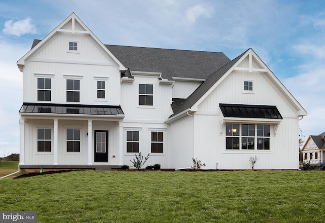 modern farmhouse featuring board and batten siding, a shingled roof, a front lawn, and a standing seam roof