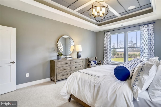 carpeted bedroom with a notable chandelier and a tray ceiling