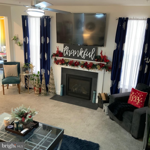 carpeted living room with ceiling fan