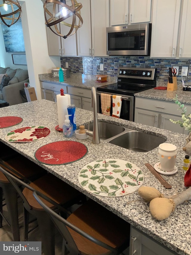 kitchen with tasteful backsplash, stainless steel appliances, and light stone counters