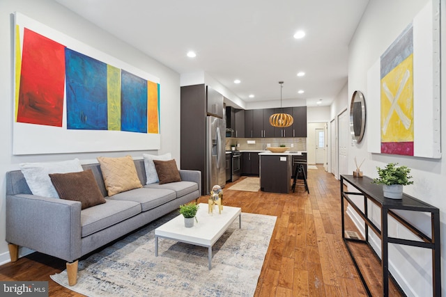 living room featuring light hardwood / wood-style flooring and an inviting chandelier