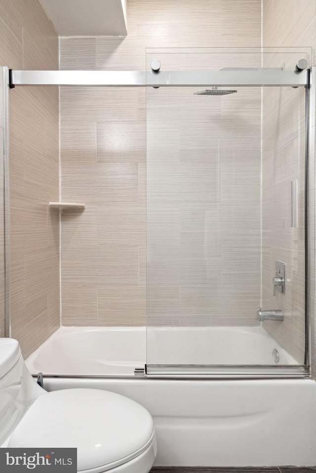 bathroom featuring toilet and enclosed tub / shower combo