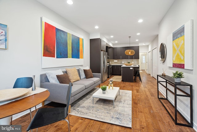 living room with light hardwood / wood-style flooring and a chandelier