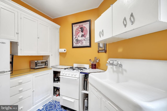 kitchen featuring white appliances, tile flooring, and white cabinetry