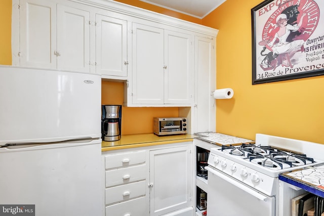 kitchen featuring tile countertops, white appliances, and white cabinetry