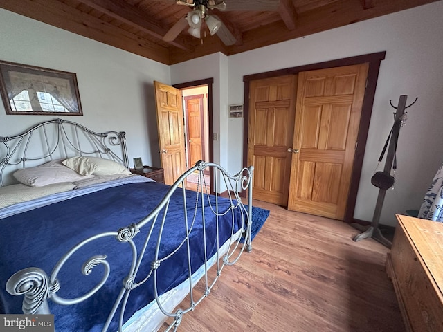 bedroom with beam ceiling, ceiling fan, wood-type flooring, and wooden ceiling