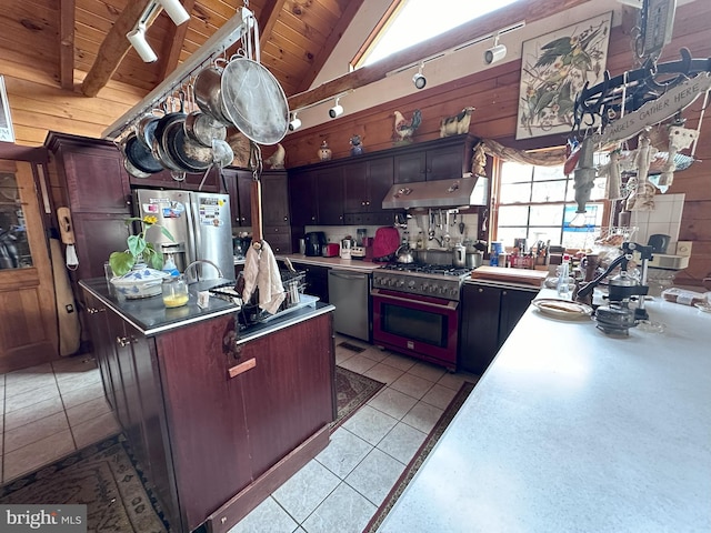 kitchen with vaulted ceiling with beams, stainless steel appliances, wooden ceiling, a center island, and light tile patterned flooring