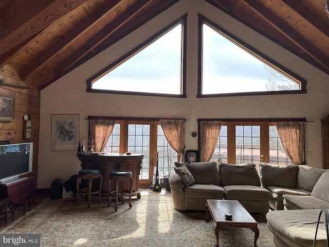 living room with beamed ceiling, a wealth of natural light, and high vaulted ceiling