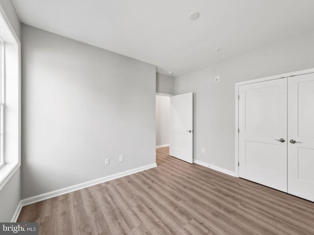 unfurnished bedroom featuring light hardwood / wood-style flooring and a closet