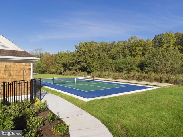 view of tennis court featuring a yard