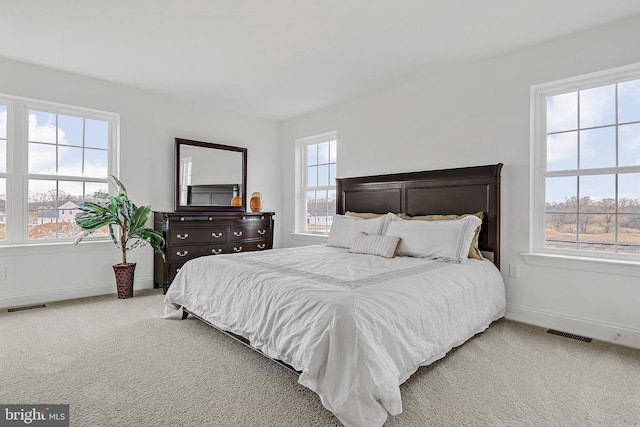 bedroom featuring multiple windows and light colored carpet