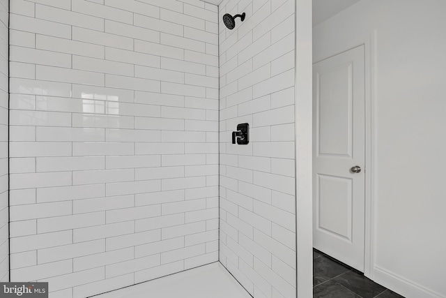 bathroom featuring a tile shower and tile floors