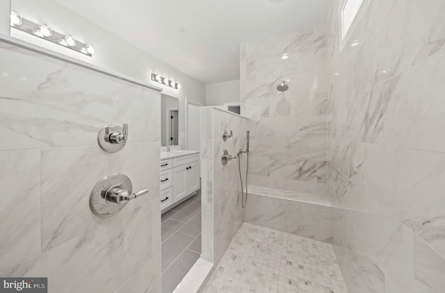 bathroom with vanity and a tile shower