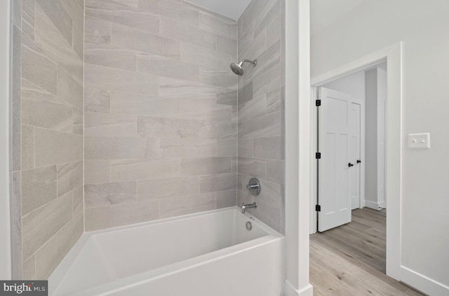 bathroom with tiled shower / bath combo and wood-type flooring