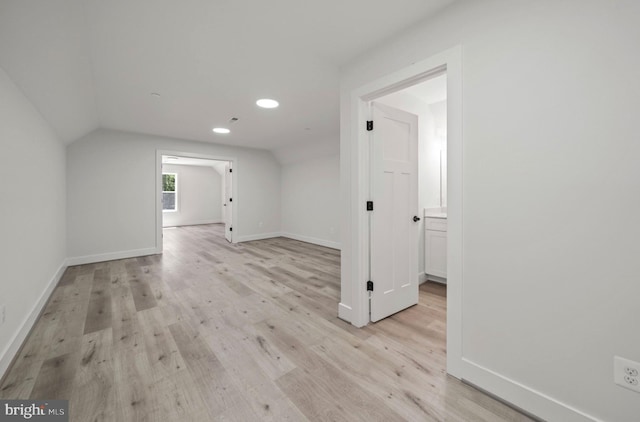 additional living space featuring lofted ceiling and light hardwood / wood-style flooring