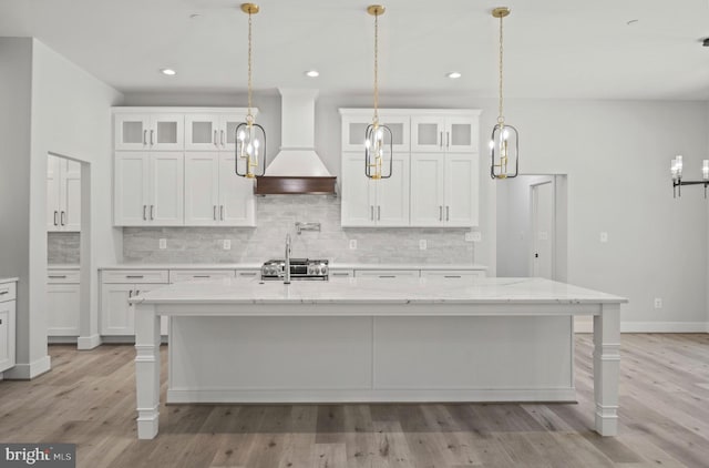 kitchen with white cabinets, premium range hood, and pendant lighting