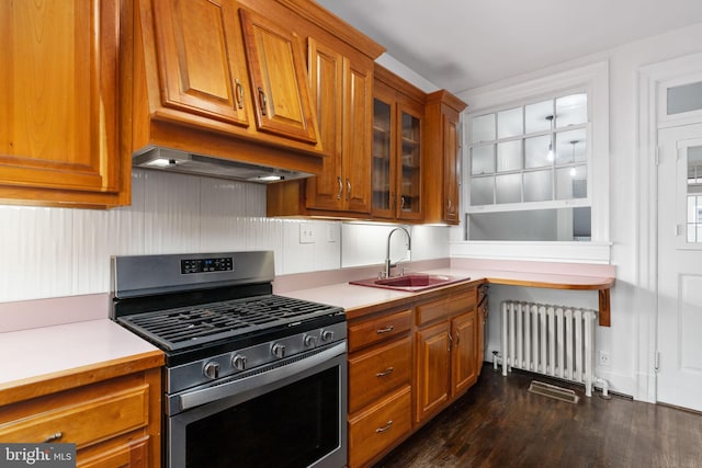 kitchen featuring dark hardwood / wood-style flooring, stainless steel range with gas stovetop, radiator heating unit, and sink