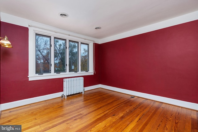 spare room with radiator and light hardwood / wood-style floors