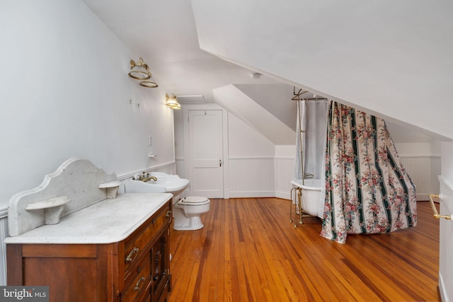 bathroom featuring hardwood / wood-style floors, toilet, vanity, and lofted ceiling