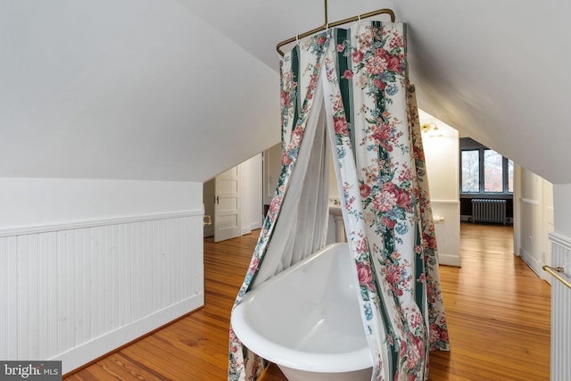 bathroom featuring hardwood / wood-style floors, lofted ceiling, and radiator heating unit