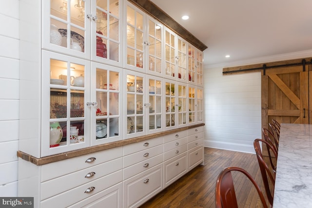 interior space with a barn door and dark hardwood / wood-style floors