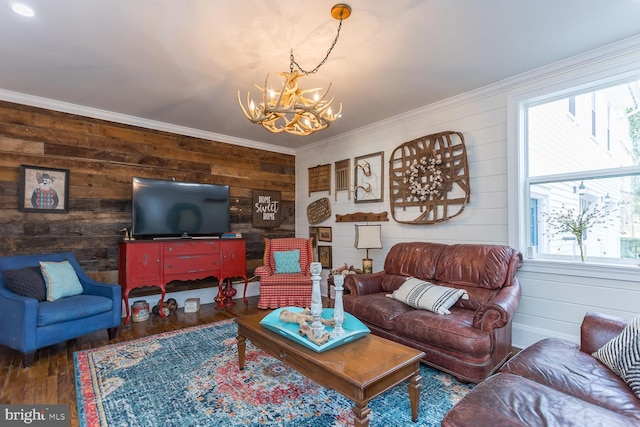 living room featuring crown molding, wood walls, hardwood / wood-style floors, and a chandelier