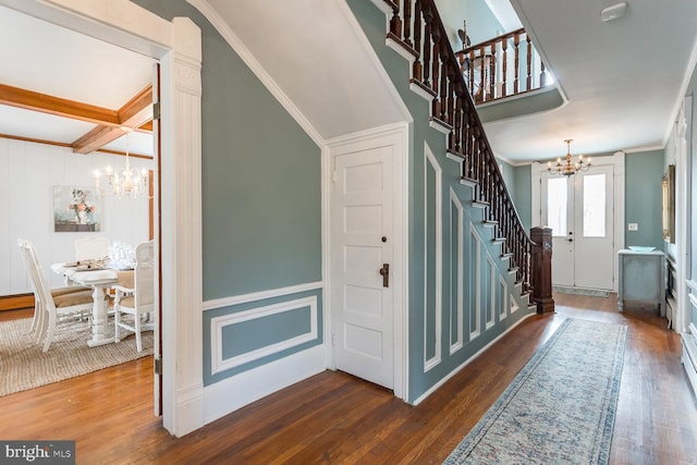 stairway featuring hardwood / wood-style floors, beam ceiling, crown molding, and a chandelier