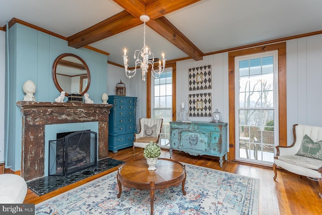 living room with ornamental molding, wooden walls, beamed ceiling, hardwood / wood-style floors, and a chandelier