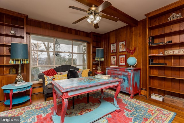 office with wood walls, ceiling fan, and wood-type flooring