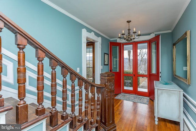 entrance foyer with hardwood / wood-style flooring, a notable chandelier, and ornamental molding