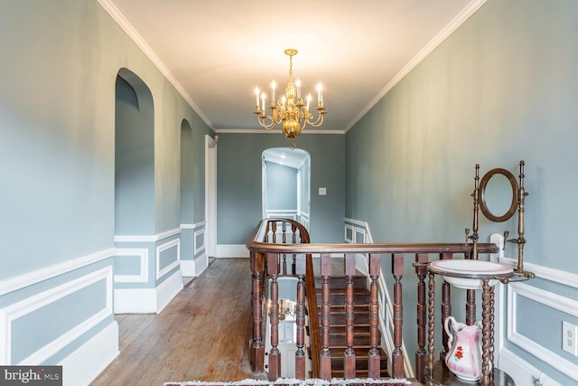 hall featuring a chandelier, wood-type flooring, and crown molding