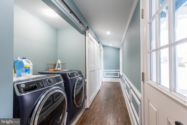 clothes washing area featuring washer and clothes dryer, plenty of natural light, a barn door, and dark wood-type flooring