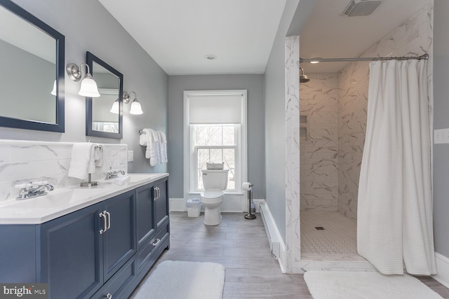 bathroom featuring wood-type flooring, vanity, toilet, and walk in shower