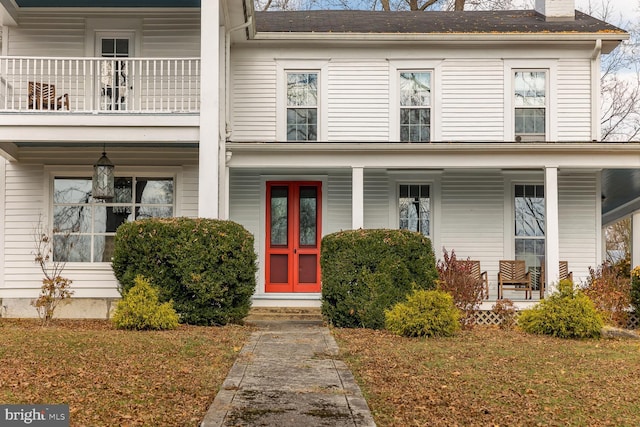 view of front of property featuring a balcony and a front lawn