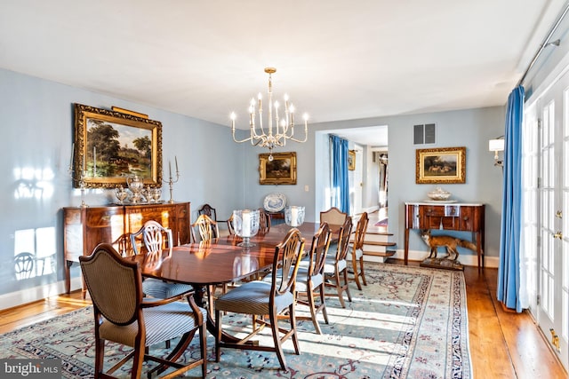 dining space featuring light hardwood / wood-style flooring and a notable chandelier