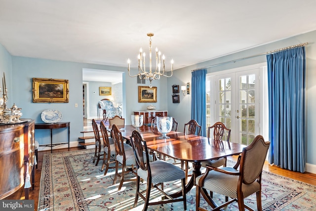 dining area featuring wood-type flooring, french doors, and a chandelier