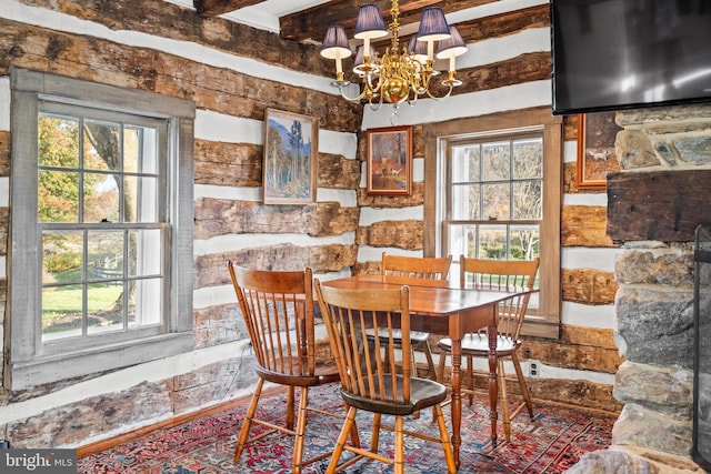 dining area featuring an inviting chandelier and beam ceiling