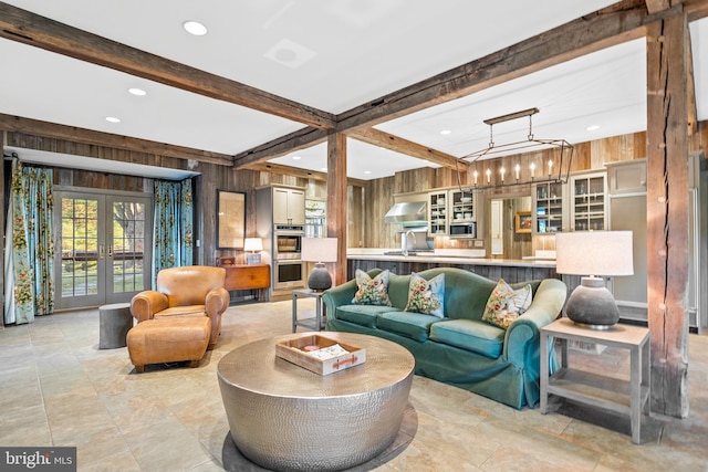 tiled living room with french doors, wood walls, and beam ceiling