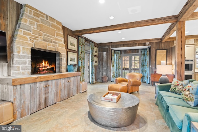 living room with beamed ceiling, wooden walls, a fireplace, and light tile floors