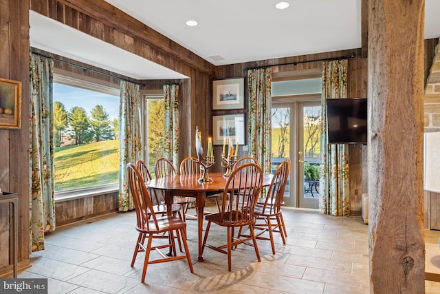 tiled dining space featuring a wealth of natural light and wooden walls