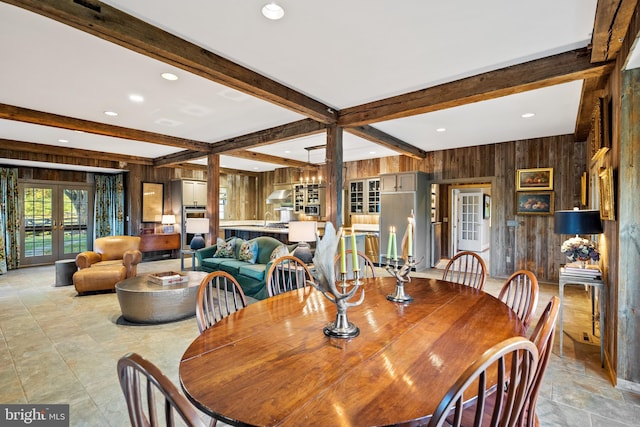 tiled dining room featuring french doors, wood walls, and beam ceiling