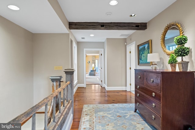 hall with hardwood / wood-style floors, beam ceiling, and a wealth of natural light