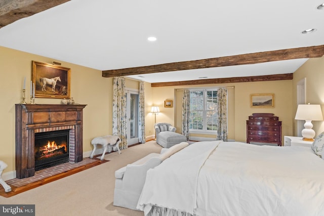 carpeted bedroom featuring beam ceiling and a brick fireplace