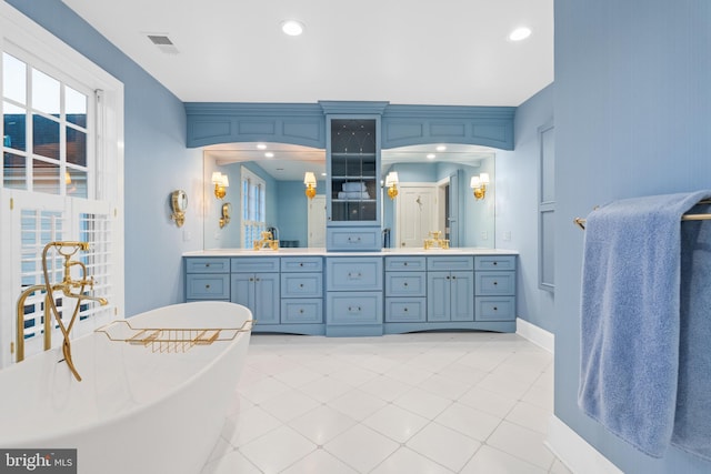 bathroom featuring large vanity, tile floors, and a washtub