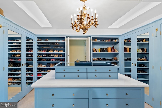 spacious closet with light colored carpet and a notable chandelier