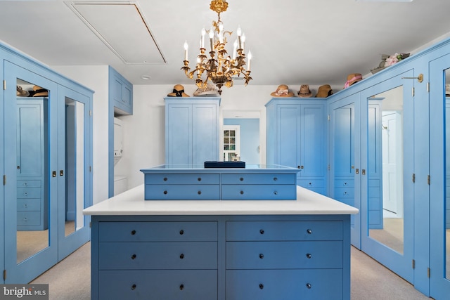 walk in closet with french doors, light carpet, and a notable chandelier