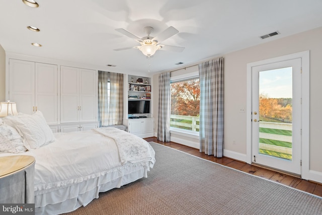 bedroom featuring wood-type flooring, ceiling fan, access to outside, and multiple windows