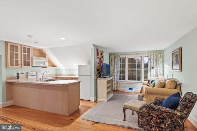 kitchen featuring white appliances, light hardwood / wood-style floors, and kitchen peninsula