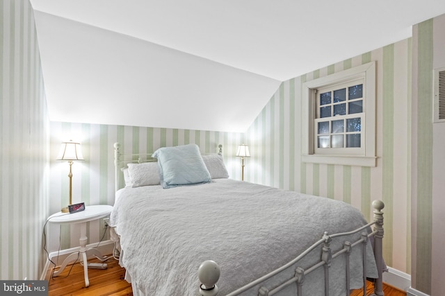 bedroom with lofted ceiling and hardwood / wood-style floors